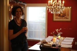 Sandra Lewis standing in a dining room with red walls.