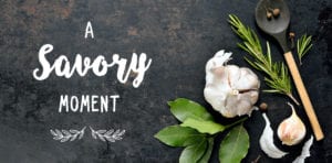 What's for dinner? A Savory Moment helps answer this question. The picture is of fresh bay leaf, garlic, rosemary and a spoon on a slate background with the words A Savory Moment.