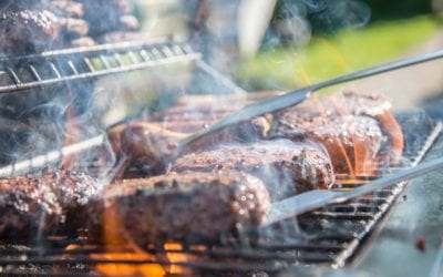 How to know when grilled meat is done. Closeup picture of steak on a grill with wispy smoke .