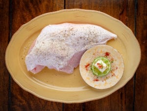 Smoked paprika cream cheese spread. Turkey fillet with lemon zest, dash of paprica and cream cheese on a plate served on the table.