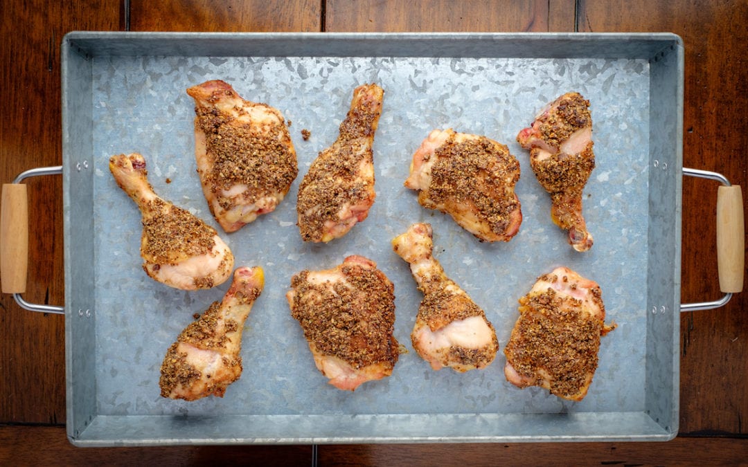 Moroccan Barbecue Chicken. | Chicken coated with ground chilis, cumin, caraway, coriander, and black peppercorns on a baking tray.