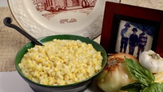Life At The Table | Creamed Corn Recipe | Creamed corn in a bowl surrounded by a plate with a picture of an old church and a photo of three kids in fishing gear.