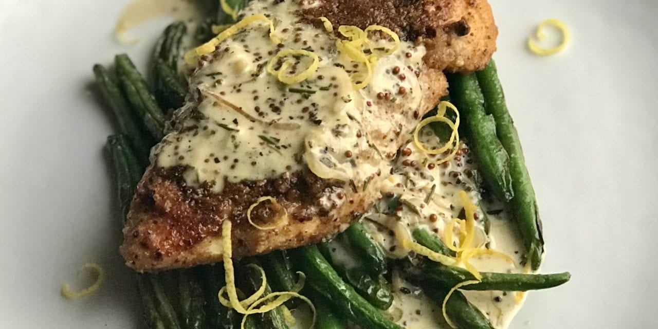 Life At The Table | Pistachio Crusted Chicken with Mustard Cream Sauce. Pan-seared chicken breast atop a bed of sautéed green means with a mustard cream sauce garnished with zest of lemon.
