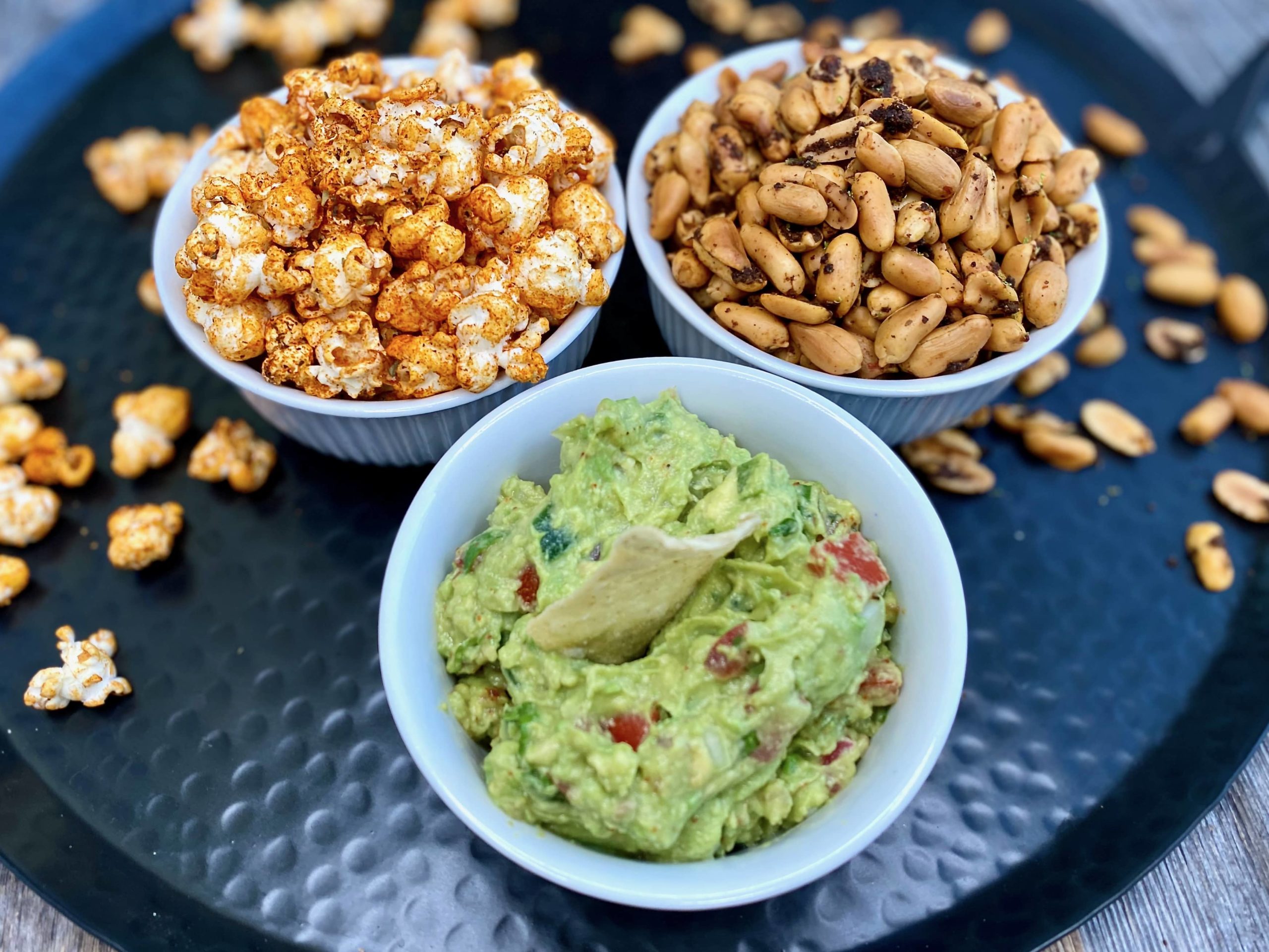 Life At The Table SuperSnack Attack Cooking Class | Guacamole, Cajun Popcorn, Chile Lime Peanuts in 3 bowls on a platter.