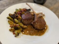 Life At The Table | Guinness Mustard Sauce. Pan-seared lamb chops with a Guinness Mustard Sauce with Brussels Sprouts on a white plate.