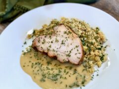 Garlic and Sage Gravy | Life At The Table. Garlic and sage gravy on a while plate accompanying a slice of turkey and cornbread dressing.