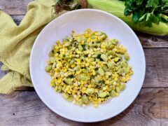 Life At The Table Succotash. Maryland succotash in a white bowl with fresh corn, parsley, and a green napkin next to it.